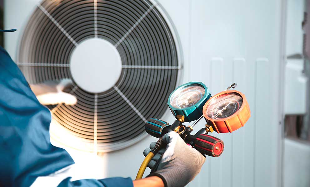 Mechanic air conditioner technician using manifold gauge checking refrigerant for filling home air conditioning and air duct cleaning and maintenance outdoor compressor unit.